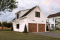 Vue avant - MODÈLE DE BASE - Plan de garage double style farmhouse avec balcon couvert, vaste rangement à l'étage, et salle d'eau prévue. - Crossroads